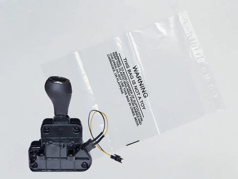 24V Realtree UTV Gear Shifter With Switches Assembly Replacement For Ride On Toys next to a transparent bag