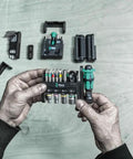 Hands holding Tool Check Modular 1 21 Piece Screwdriving Set Ultra Compact Pro Grade Versatile Kit with components visible on table.