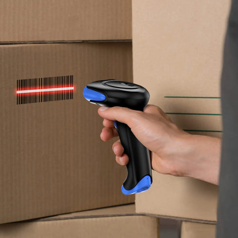 Hand holding a 2D Bluetooth Barcode Scanner with 3 in 1 Connectivity scanning a barcode on a cardboard box in a warehouse setting.