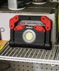 Omni 2K Rechargeable Work Light with 2000 Lumens Six Light Modes rotating magnetic handles on shelf