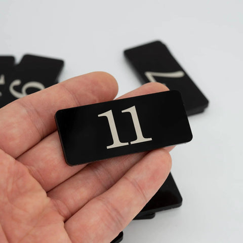 Hand holding Plastic Rectangle Numbered Stickers 1 To 50 Black Waterproof Self Adhesive Backing For Lockers Doors Tables And More