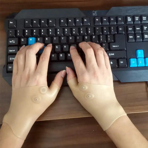 Hands wearing Thumb And Wrist Support Brace 2 Pack With Elastic Gel Fingerless Glove typing on keyboard for pain relief and wrist support