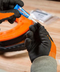 Klein Tools 56025 non-conductive fish tape repair kit, close-up of blue glue being applied to a repair part