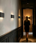 Modern Wood LED Linear Wall Sconce, Mini Up Down Wall Mount Light, Hardwired, UL Listed, Wood Wall Lighting Fixture for Bedroom, Living Room, Stairway, Hallway, (Black) 2 Pack illuminating a stylish hallway.