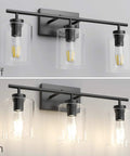 Three Light Black Vanity Light Fixture Over Mirror With Clear Glass Shades Industrial Wall Light For Bathroom Upgrade Modern Vintage Look Matte Black Frame, shown off and on.