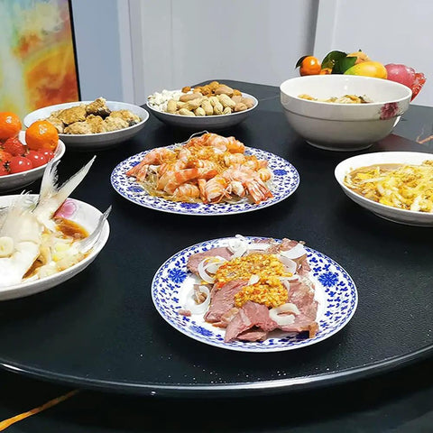 Generous Black Tempered Glass Lazy Susan Turntable displaying various dishes including shrimp and meat plates for dining.