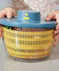 No Sweat Electric Salad Spinner With Single Button Control For Swift Leafy Greens Washing And Thorough Fruit Vegetable Drying Generous Four Liter Capacity held with lid on, showcasing spinning basket.