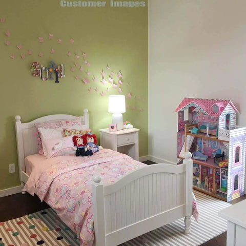 24 Pack Pink Kawaii 3D Butterfly Wall Stickers Removable Mural Decals For Home And Girls Room Decor Waterproof Easy To Clean Vibrant Nature Inspired Accent next to a white bed and dollhouse in a girls' bedroom.