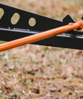 Close-up of Skid Steer Sod Roller With Adjustable 36in 44in 52in Widths, orange frame on grassy field