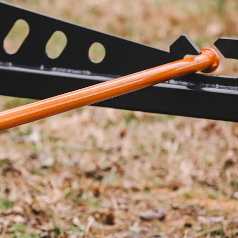 Close-up of Skid Steer Sod Roller With Adjustable 36in 44in 52in Widths, orange frame on grassy field