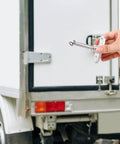 Hand holding Heavy Duty Van Door Holder And Trailer Door Retainer Catch For Commercial Trucks Rust Resistant Exterior Noise Reducing
