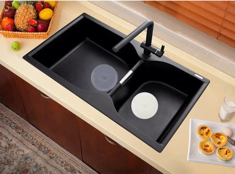 Slick Six Inch Silicone Tub Stopper Two Pack Soft Drain Plug Hair Catcher in black sink blocking clogs while washing.