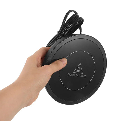 Electric Coffee Cup Warmer Desk Mug Heater Keeps Your Daily Sips Scalding Hot All Day Long Without Giving You Any Headaches Thanks To Simple Touch Controls And Four Hour Auto Shut Off, hand holding black circular pad.