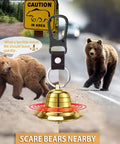 2 Pack Loud Bear Bell Set With Silencer And Emergency Whistle Carabiner in front of bears, caution sign in background