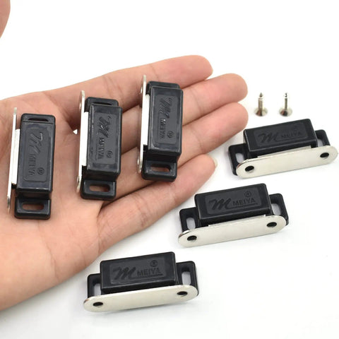 Person holding Heavy Duty Magnetic Cabinet Door Catches Pack Of 12 With Mounting Screws, Fifteen Pound Hold Per Magnet, Black Finish