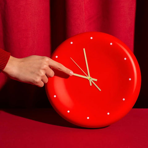 A hand adjusts gold clock hands on a red clock face from Metal Clock Hands Replacement Kit 10 Sets Handy DIY Wall Clock Hands for repair.