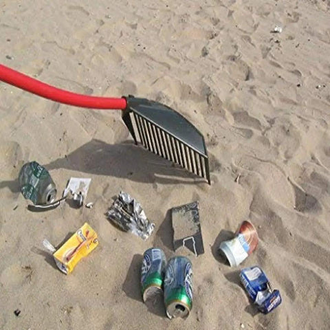 Heavy Duty Garden Rake That Slays Leaves And Debris With Ease showing red handle and sturdy tines on sandy ground with trash