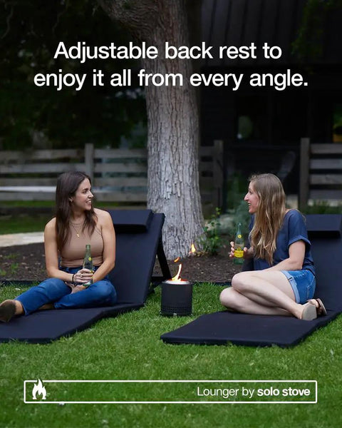 Two women sitting on Adjustable Chaise Lounge With 2 Inch Foam Pad And Portable Carry Case outdoors, near a firepit.