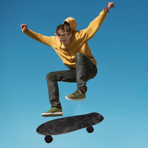 Skateboarder performing a trick, using contour map grip tape for skateboards 33 by 9 inches, black with white contour lines.