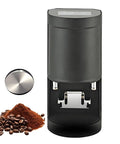 Top Notch 58 Mm Electric Coffee Tamper And Powder Press With Smart Touchscreen Dial, black device beside coffee grounds and beans.