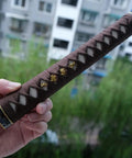 Close-up of Katana Tsuka Handle For Japanese Sword With 10.2 Inches Alloy Copper Iron Fittings And Genuine Samegawa Ray Skin Wrapping held in hand
