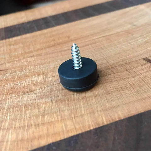 Single soft rubber foot with stainless screw on wooden surface, part of 25 Soft Rubber Feet With Stainless Screws For Cutting Boards And Electronics, Quarter Inch Tall And Half Inch Wide Non Slip Bumpers, Full Thread Stainless Steel Screws Included, Great For Cabinets, Tables, And Small Appliances