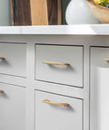 Champagne bronze cabinet handles on white kitchen drawers, showcasing 5-inch 128mm hole centers zinc alloy pulls in a modern minimalist style.