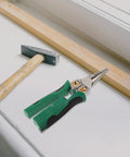 Rock Solid Multi Function Wire Strippers With Voltage Tester And Cutters on a workbench beside a hammer and wood.