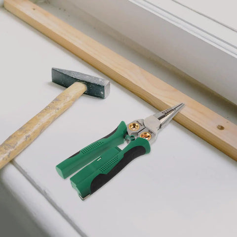 Rock Solid Multi Function Wire Strippers With Voltage Tester And Cutters on a workbench beside a hammer and wood.