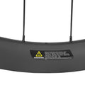 Close-up of the Carbon Fiber Disc Brake Wheelset For Road Bikes Tubeless Ready 28mm Rim 700c with warning label visible