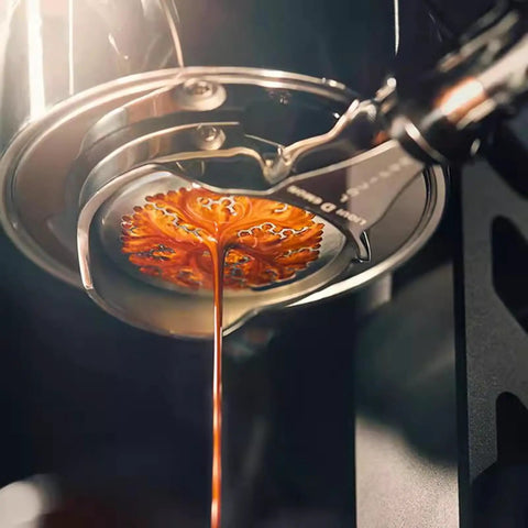 Close-up of espresso pouring from 58mm brew head of hand cranked espresso machine, showcasing rich crema for silky lattes.