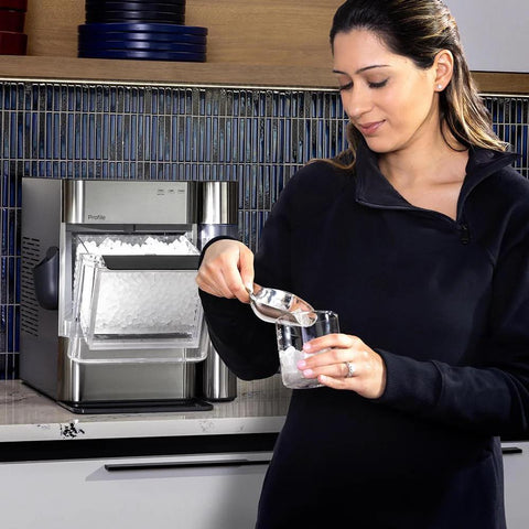 GE Profile Opal 2.0 Ultra nugget ice maker in stainless steel on kitchen counter with clear ice bin and scoop included