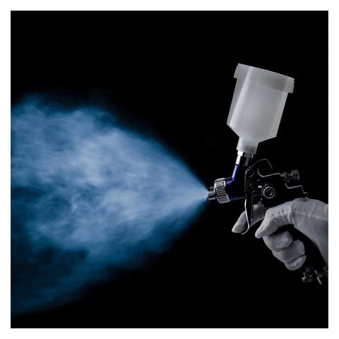 Top Shelf Boss Pro Grade Hvlp Spray Gun Combo Pairing 0.8 And 1.0 Mm Nozzles in use, spraying blue mist, gravity feed airbrush.