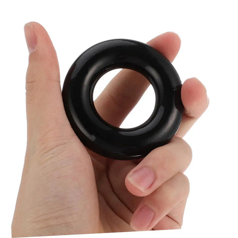 Close-up of hand holding black ring from Two Pack Weighted Golf Swing Trainer Rings For Beginners, Warm Up Practice Tool.