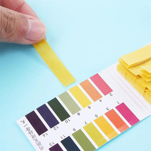 Person using 80 Strips Pack PH Tester Strips Full Range 1 to 14 Litmus Paper for chemistry experiments with color chart visible