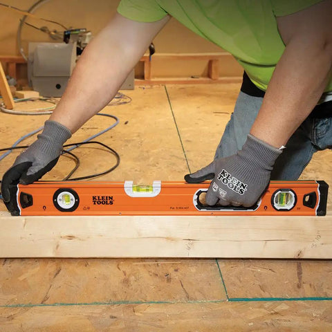 Person using 935L 24-Inch Magnetic Bubble Level With Adjustable Vial And Top V-Groove for pipe alignment on construction site