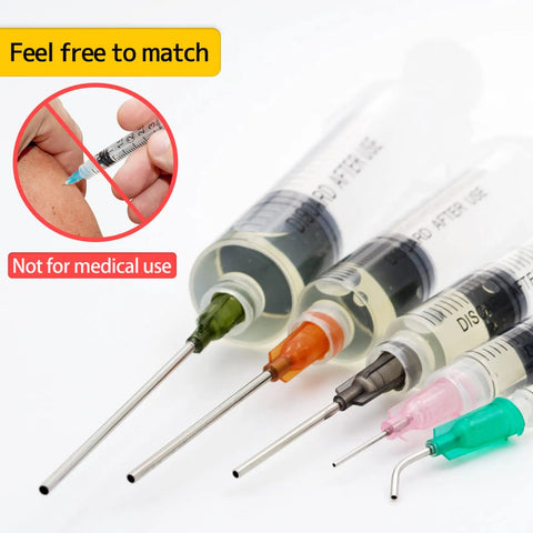 Close-up of Pro Grade Glue Applicator Syringe Set with blunt tip needles and colorful caps for non-medical use, shown at angle.