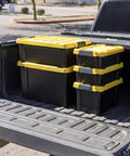 12 Gallon Heavy Duty Storage Tote Set of 3 Black Plastic Bins Featuring Secure Yellow Lids arranged in a truck bed.