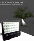 JUDYSSY Solar Flood Lights Led Flood Light, 30W 3000Lm IP65 Waterproof Outdoor Security Light shown outdoors next to a tree.