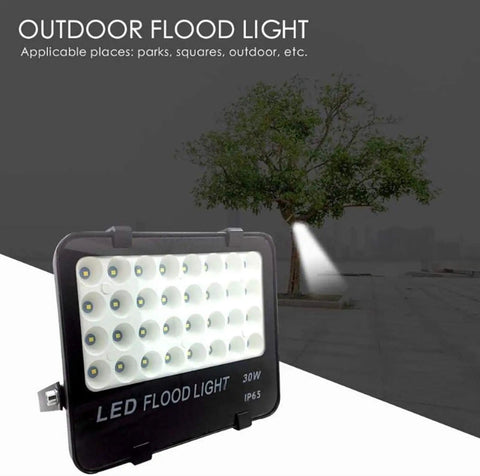 JUDYSSY Solar Flood Lights Led Flood Light, 30W 3000Lm IP65 Waterproof Outdoor Security Light shown outdoors next to a tree.