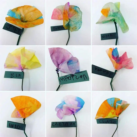 Nine handmade colorful paper flowers with names on tags, arranged in a 3x3 grid, showcasing creative designs.