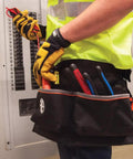 Electrician using Heavy Duty Tool Apron With Reinforced Bottoms And Four Pockets For Hand Tools Tape Thong And Pencil Pockets Adjustable Belt