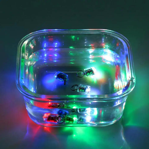 5 Pack LED Fishing Lights For Deep Water Drops inside a clear bowl, emitting multicolored lights underwater, water activated auto on.