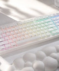 Wireless Mechanical Gaming Keyboard With 95 Percent Layout And Integrated Number Pad In Cream White Glossy Cat Ear Keycaps Running Smooth Creamy Switches With Vibrant Rgb Lighting For Your Sick Desk Setup on a white surface.