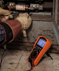 Electrician using Auto Ranging TRMS Digital Multimeter For 1000V AC DC Voltage 10A Current in industrial setting