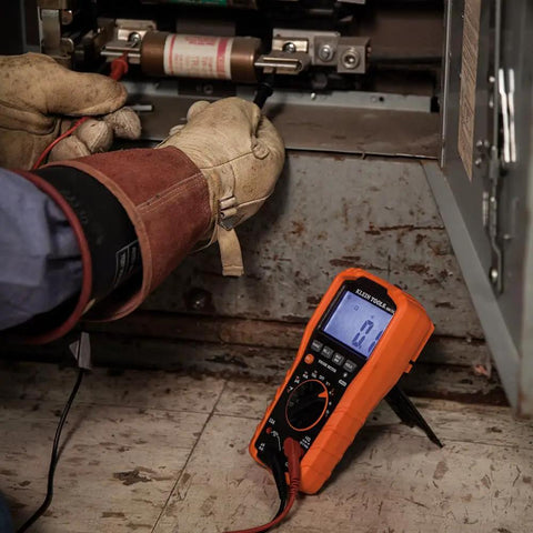 Electrician using Auto Ranging TRMS Digital Multimeter For 1000V AC DC Voltage 10A Current in industrial setting