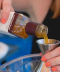 Pouring ingredient into Double Jigger Cocktail Set 1oz/2oz Stainless Steel Barware for home bar use with markings visible