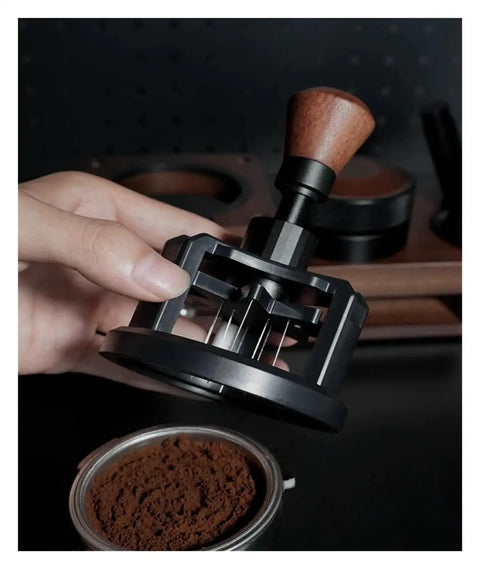 Heavy Duty 58 Millimeter Espresso Portafilter Needle Distributor With Built In Magnet, held above coffee grounds.