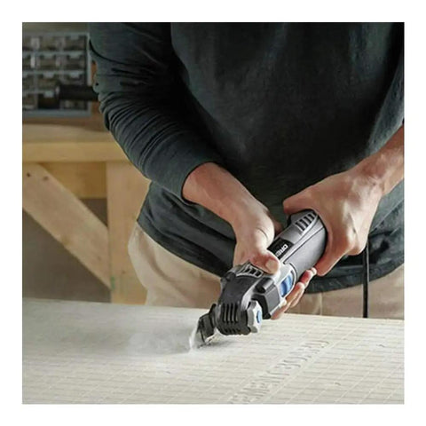 Man using 5 Amp Tool-Less Oscillating Tool Kit With Accessory Set For Cutting Sanding Grinding And Scraping on wooden board