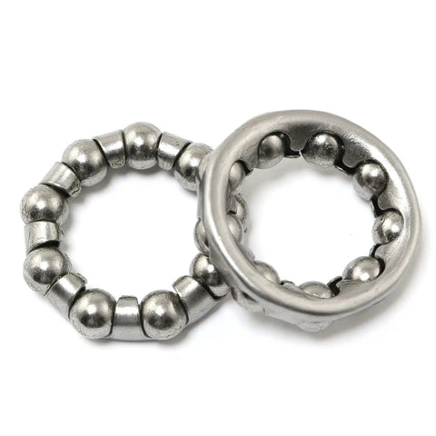 Close-up of two stainless steel bicycle ball bearings with nine ball cage, ideal for crank and bottom bracket replacement, 29mm OD, 18.2mm ID.